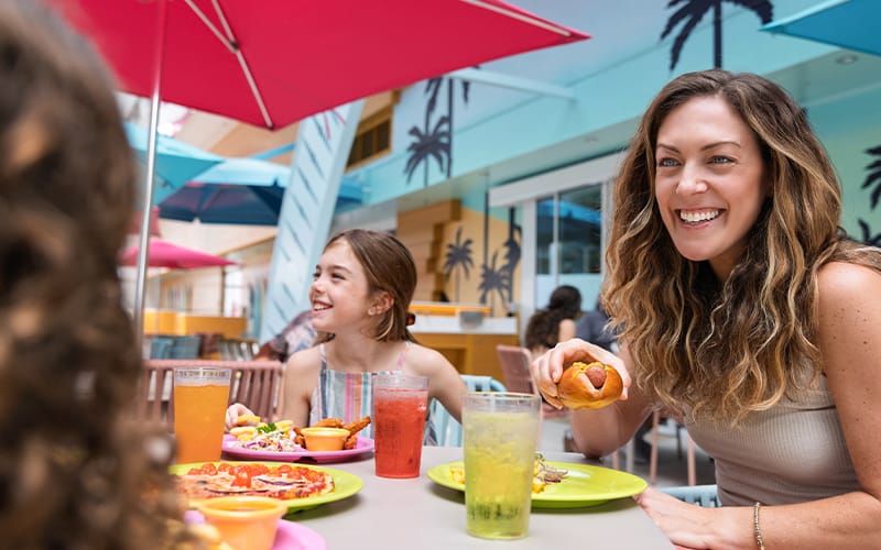 Madre e hija disfrutando de un almuerzo al aire libre en un restaurante de la cubierta del barco.