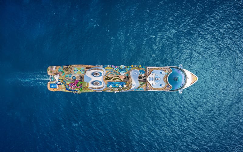 Vista aérea de la piscina, toboganes y áreas recreativas en la cubierta superior de un barco de Royal Caribbean.