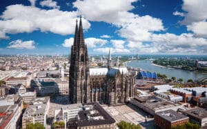 Vista aérea monumental de la Catedral de Colonia junto al río Rin en un día despejado.