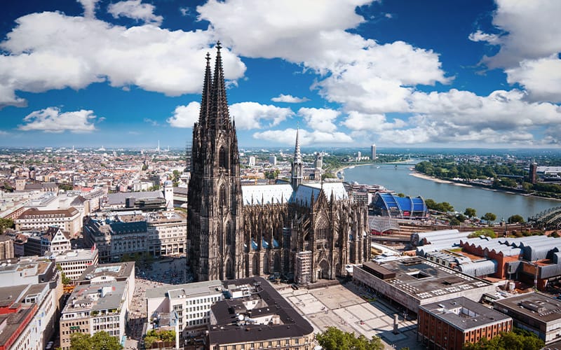 Vista aérea monumental de la Catedral de Colonia junto al río Rin en un día despejado.