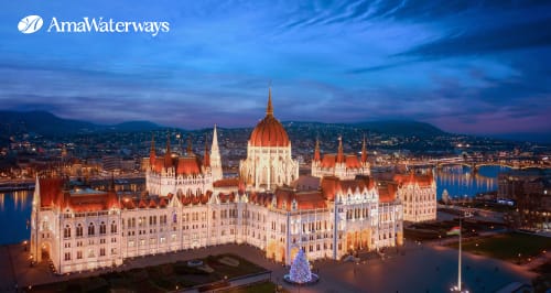 Fachada iluminada del Parlamento de Budapest junto al río Danubio durante la temporada navideña.